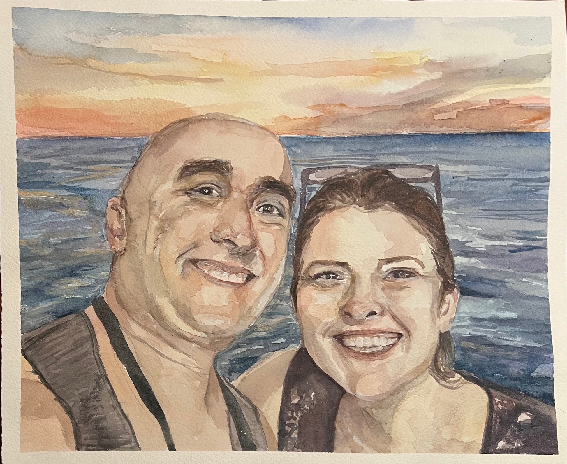 watercolor painting with two adults smiling by the ocean at a sunset