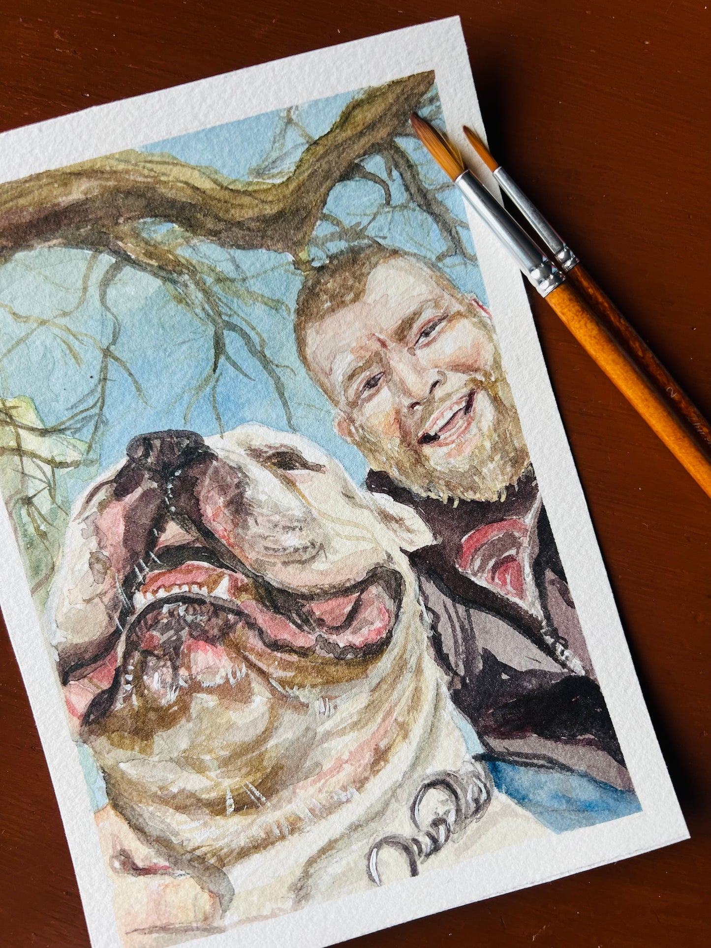 watercolor painting with a man smiling by his dog