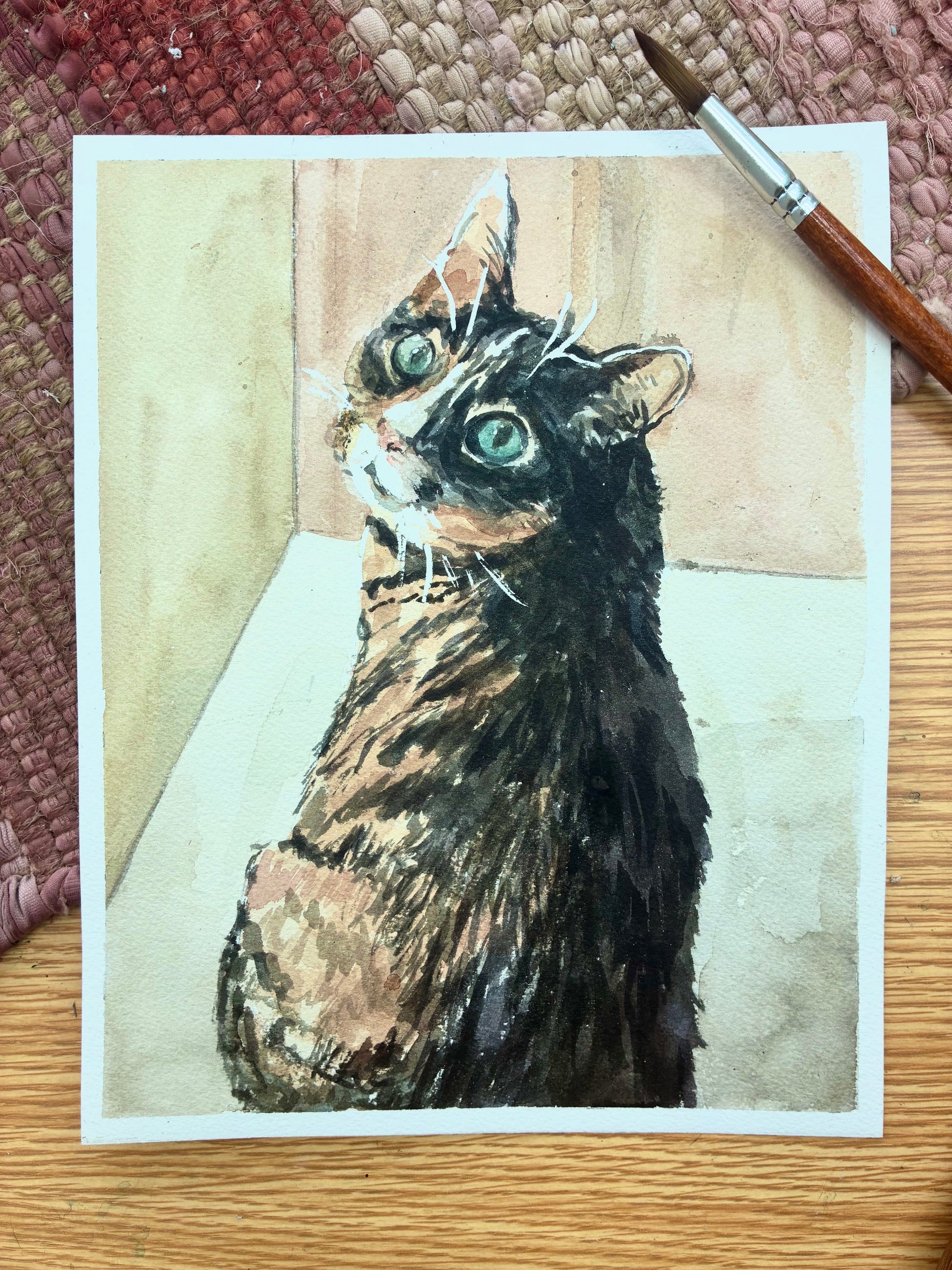 This is a watercolor painting of a cat looking at the camera